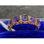 Jewellery: Yellow metal half hoop ring set with five graduated amethysts, estimated weight of (5)