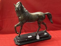 20th cent. Bronze figure of a prancing horse on a stepped black marble base.