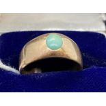 Jewellery: Yellow metal ring in the form of a tapering band set with an oval cabouchon cut turquoise