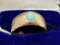 Jewellery: Yellow metal ring in the form of a tapering band set with an oval cabouchon cut turquoise