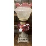 Victorian oil lamp cast iron base, cranberry glass reservoir vase line glass shade. 22ins.