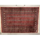 Carpets & Rugs: Late 19th cent. Turkman rug, red ground with a central panel containing sixty guls