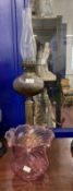 Victorian oil lamp black ceramic base, reeded brass column, ribbed pink glass reservoir. 28ins.