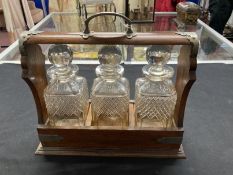 Late 19th cent. Oak Tantalus containing three cut glass decanters, silver plated mounts and