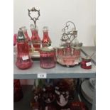 Glass: 19th cent. Cranberry glass cruet set in plated stand six bottles and stoppers, one bottle