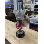 Victorian oil lamp black ceramic base, brass column, cranberry glass reservoir, clear glass shade,