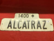 Signs: Post-war American street sign '1400 Alcatraz'. Black letters in relief on a white background.
