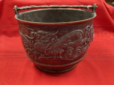Early 20th cent. Chinese bronze rice pot depicting a dragon on both sides and a shaped handle. 6ins.