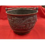 Early 20th cent. Chinese bronze rice pot depicting a dragon on both sides and a shaped handle. 6ins.