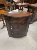 Early 19th cent. Mahogany corner bow front washstand with lift up lid, two cupboard doors, brass