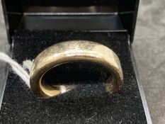 Jewellery: Yellow metal 6mm plain band, tests as 9ct gold. Ring size V½. Weight 14.8g.