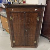 Early 19th cent. Oak corner cupboard with three shaped shelves, moulded cornice, cross banded doors,