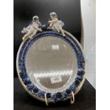 19th cent. Porcelain oval framed mirror, bevelled glass, decorated with cherubs and flowers. Approx.