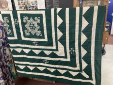 Textiles: Quilt, green ground, fawn square geometric design with bands radiating out to the edges.