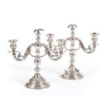A PAIR OF SILVER TWO-LIGHT CANDELABRA SURMOUNTED BY AN EAGLE
