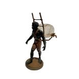 LIQUOR CELLAR REPRESENTING A NUBIAN CARRYING ON HIS BACK AN ENAMELLED GLASS LIQUOR BARREL