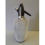 A Soda Siphon With Mesh Covering