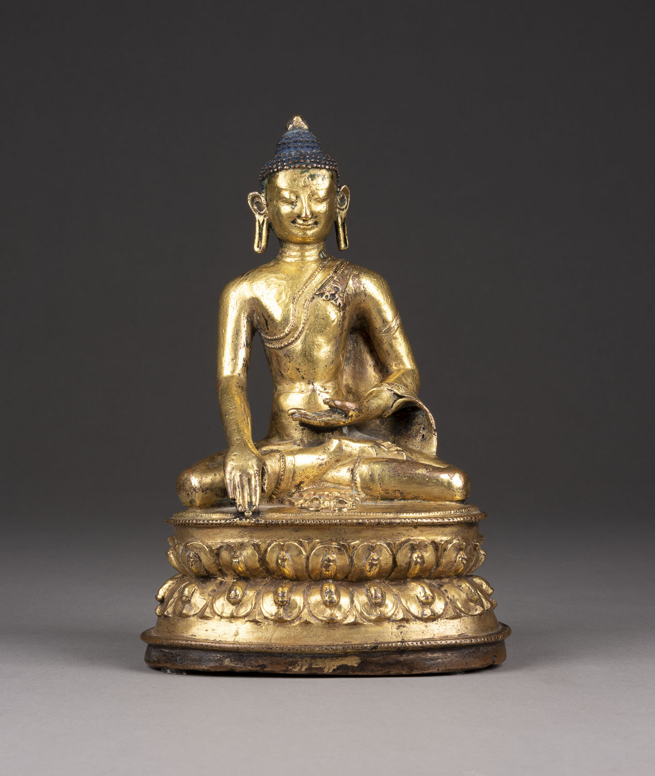 EINE VERGOLDETE SITZENDE FIGUR VON SHAKYAMUNI AUS BRONZE