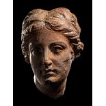 A Greek Terracotta Female Head Height 1 9/16 inches (4 cm).