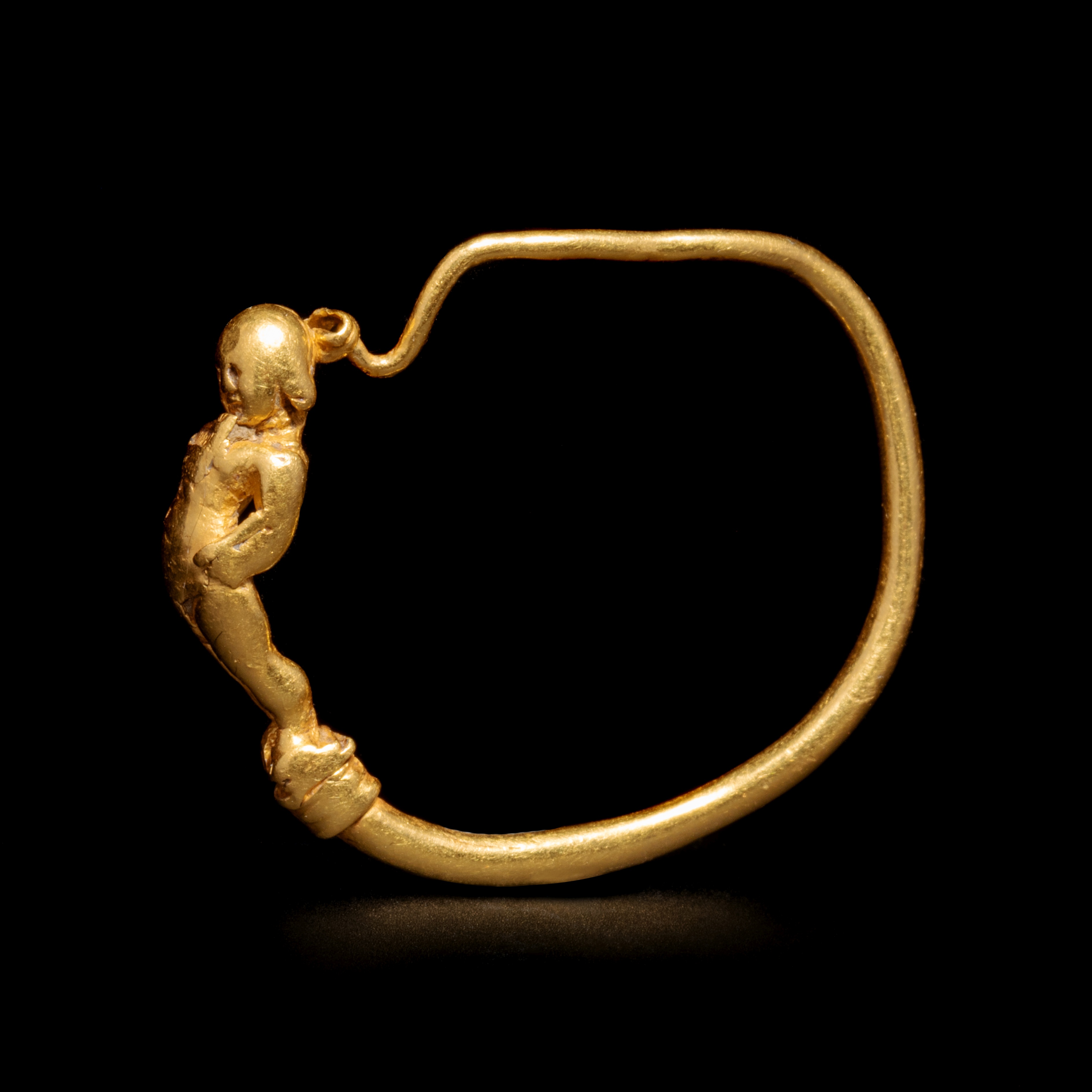 A Hellenistic Gold Earring with Eros Playing the Flute Diameter 1 1/8 inches (3 cm). - Image 7 of 9