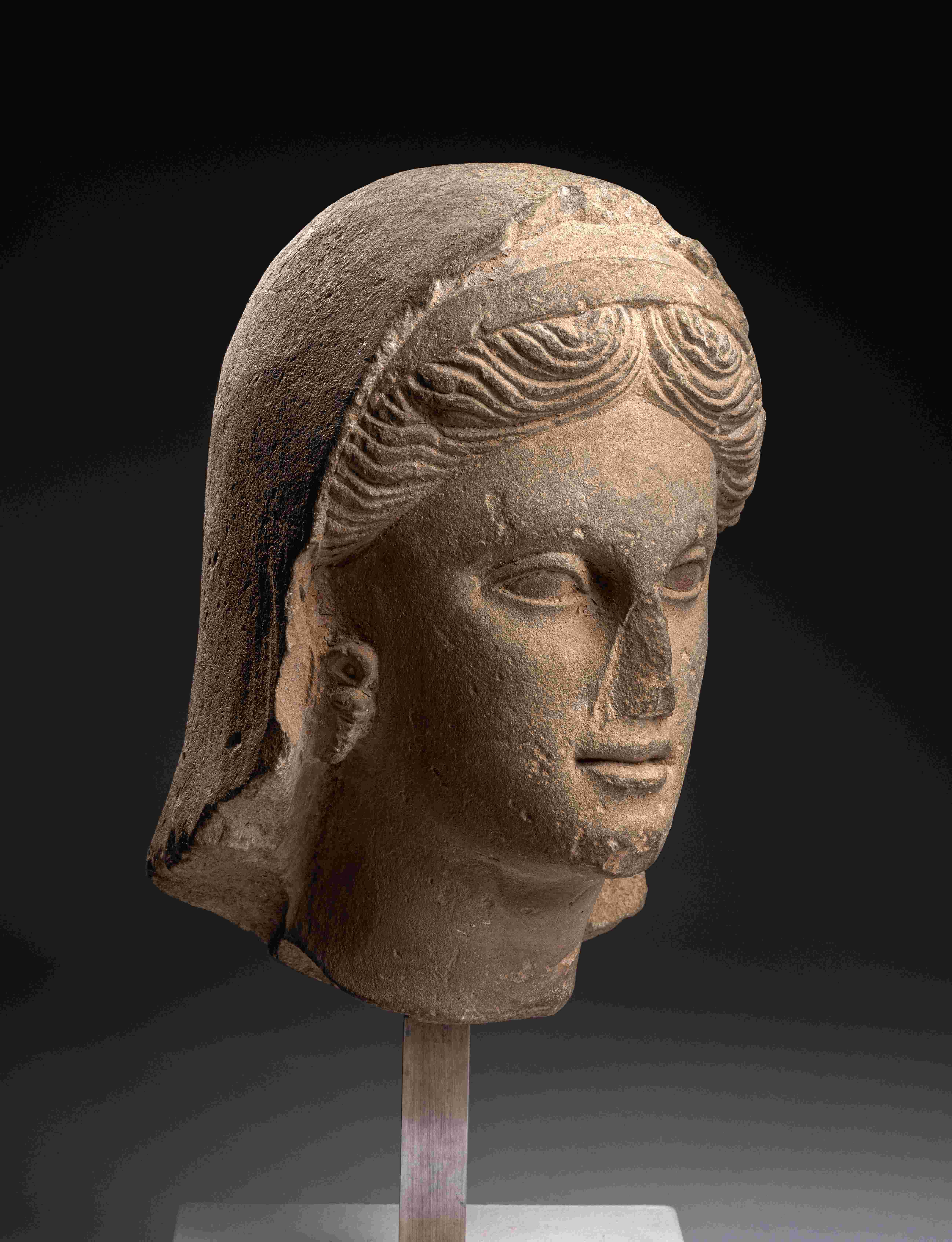 A Greek Limestone Head of a Woman Height 13 inches (33 cm).