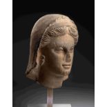 A Greek Limestone Head of a Woman Height 13 inches (33 cm).