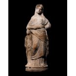 A Greek Terracotta Standing Draped Female Deity Height 6 1/2 inches (17 cm).