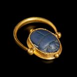 An Egyptian Faience Scarab Swivel Ring Ring size 7 1/2; Length of scarab 1/2 inch (1.25 cm).