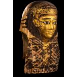 An Egyptian Gilt Cartonnage Mummy Mask Height 18 1/2 inches (47 cm).