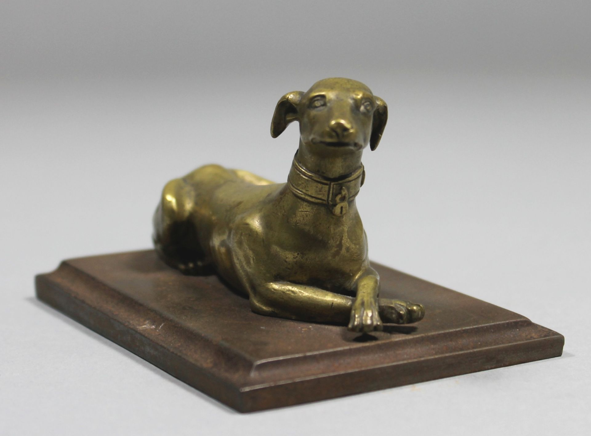 1 kleine Figur Messing, montiert auf einer quadratischen Metallplinthe "liegender Hund", keine