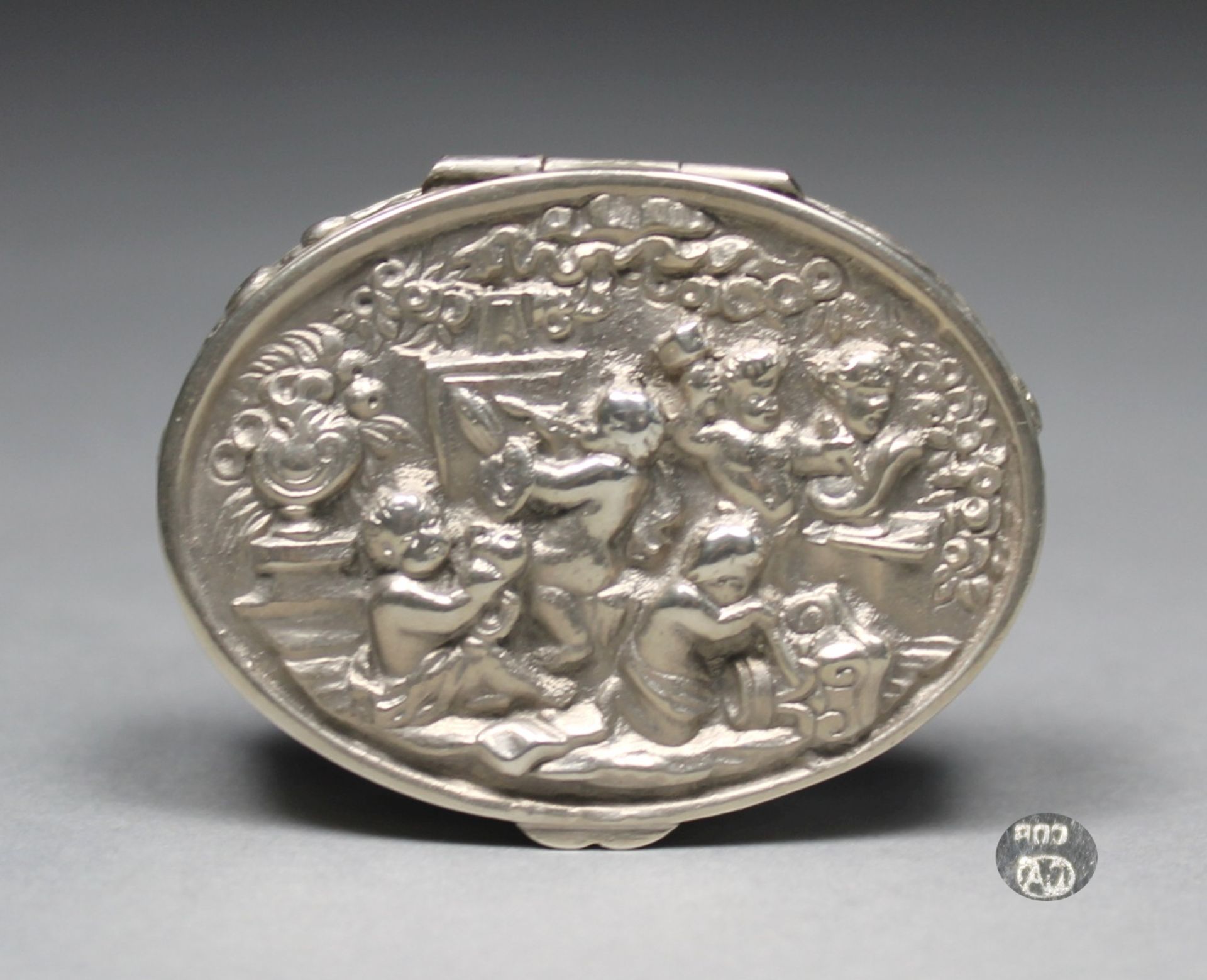 1 kleine Pillendose Silber (800/000), punziert, Deckel mit erhabenem Amorettendekor, Wandung mit