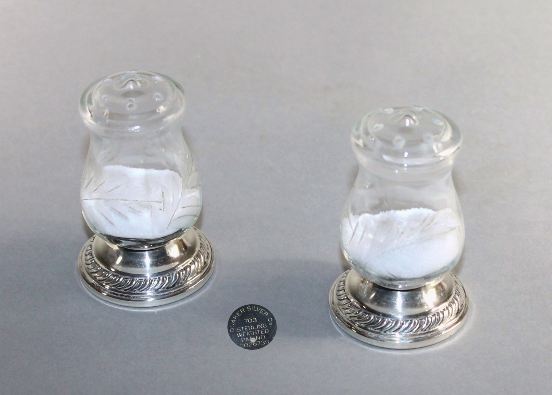 2 kleine Salz-und Pfefferstreuer Glas, Wandung mit geäztem Dekor auf Silberstand "Quaker Company",