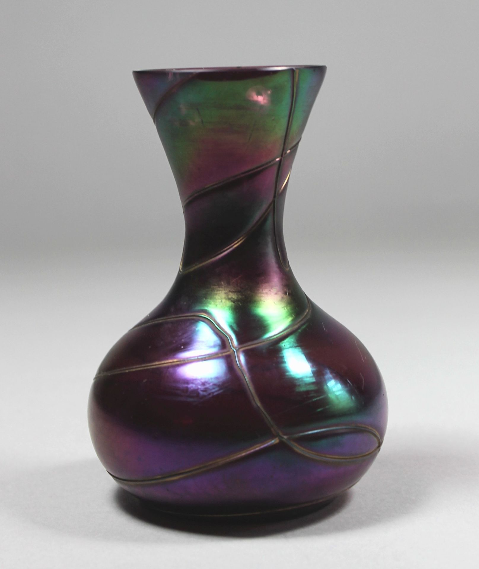 1 kleine Vase Glas, irisierend in Violettönen, Wandung mit Fadeneinschmelzungen, H ca. 15cm, Rand