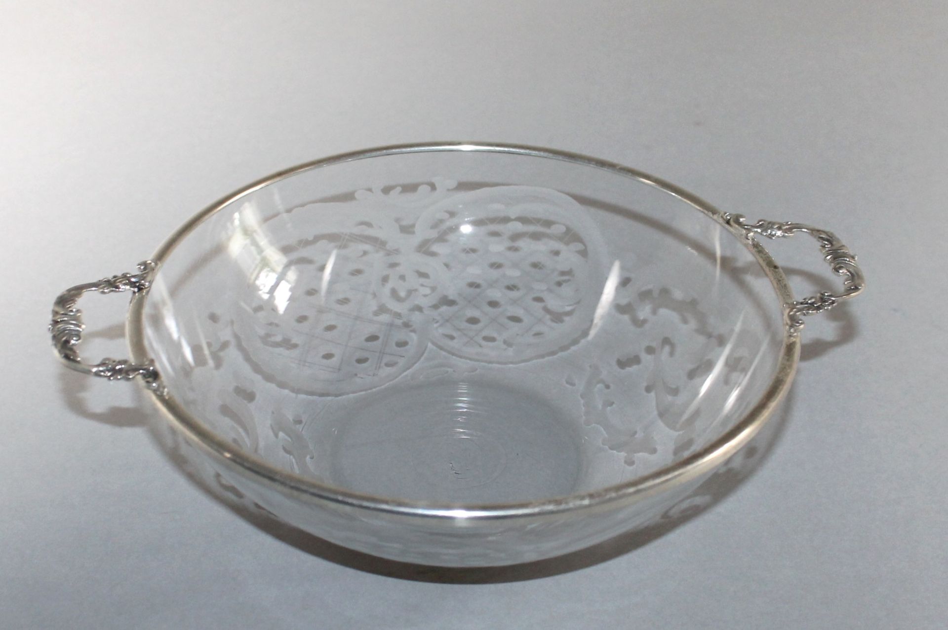 1 kleine Schale Glas, Wandung dekorativ beschliffen, Rand mit Silbereinfassung (835/000) und 2