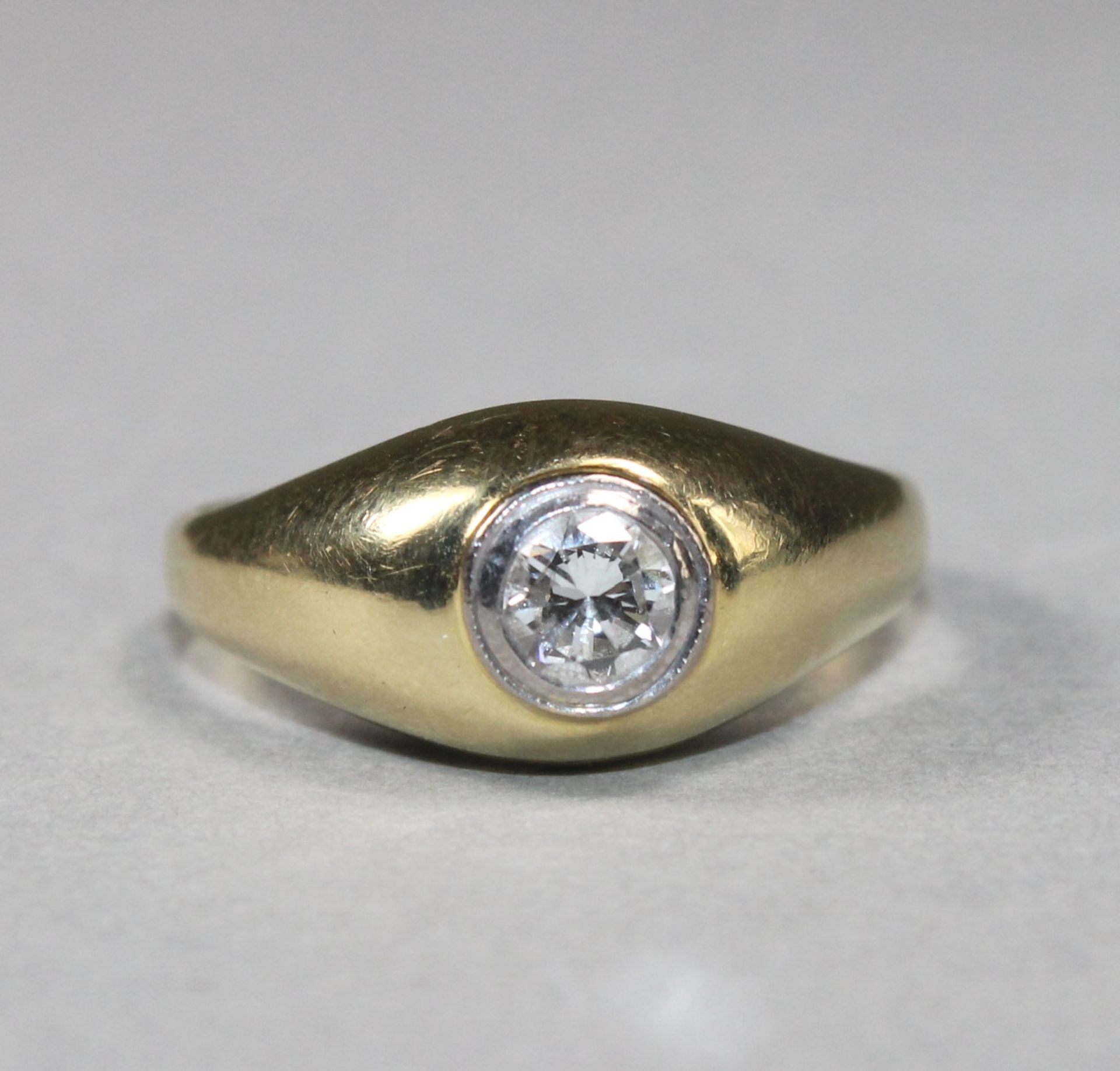 1 Ring 14kt.Gg (585/000), breiter Reif, Ringkopf besetzt mit 1 Brillant ca. 0,20ct., RG 21,