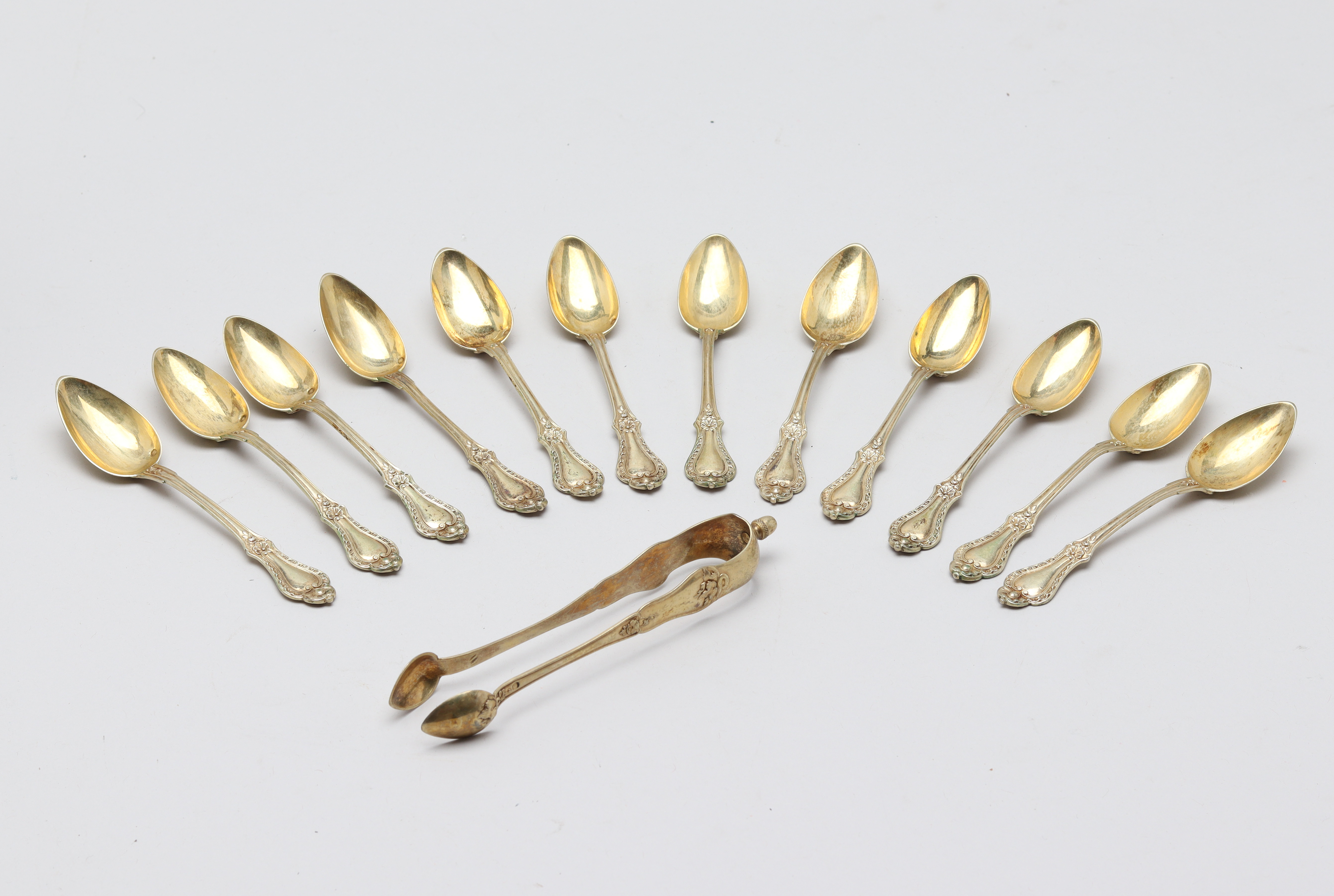 A SET OF TWELVE FRENCH SILVER TEA SPOONS AND TONGS