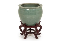 A CELADON PLANTER ON HARDWOOD STAND