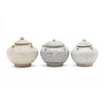 THREE SIMILAR STONEWARE JARS AND COVERS