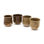 A GROUP OF FOUR POTTERY BEAKERS