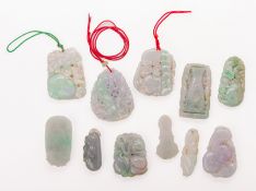 A GROUP OF ASSORTED CARVED JADE PENDANTS
