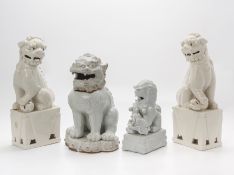 A GROUP OF FOUR WHITE GLAZED FOO DOGS