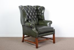 A GEORGE III STYLE GREEN LEATHER WING BACK ARMCHAIR