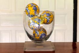 A GLASS VASE WITH CERAMIC BALLS