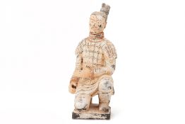 A TERRACOTTA FIGURE OF A KNEELING WARRIOR