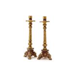 A PAIR OF CARVED GILT AND RED LACQUER CANDLESTICKS