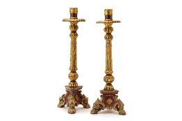 A PAIR OF CARVED GILT AND RED LACQUER CANDLESTICKS