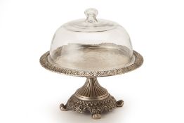 A SILVER TONED CAKE STAND WITH GLASS COVER