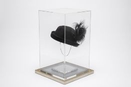 A BLACK FEATHERED HAT ON STAND