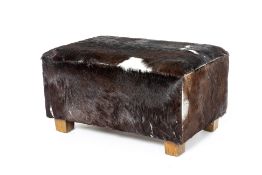 A COW HIDE FOOT STOOL/OTTOMAN