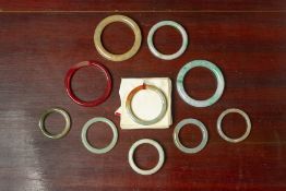 A GROUP OF TEN ASSORTED JADE AND HARDSTONE BANGLES